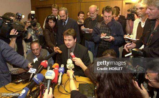 Luxembourg's interior minister Michel Wolter surrounded by journalists as he answers questions about an armed man who took 46 children and adults...