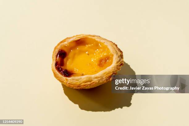 egg tart on yellow colored background - pastel de nata stock pictures, royalty-free photos & images