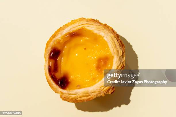 egg tart on yellow colored background - egg tart stockfoto's en -beelden