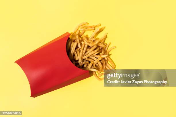 french fries on yellow background - french fries stock pictures, royalty-free photos & images