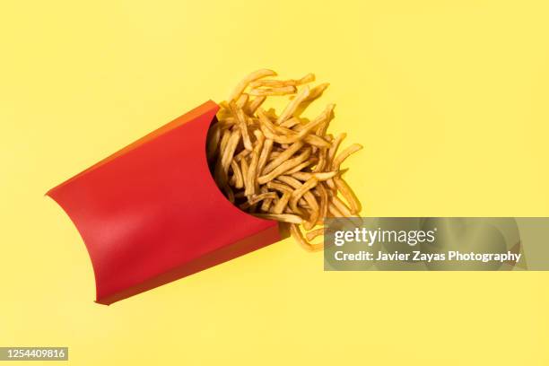 french fries on yellow background - batata frita francesa imagens e fotografias de stock