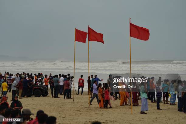 Tourists are seen gathered beside the shore of the beach on May 13, 2023 in Cox's Bazar, Bangladesh. Bangladesh has raised the cyclone warning signal...