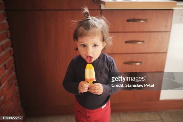 small girl eating handmade icecream in kitchen - girls licking girls stockfoto's en -beelden