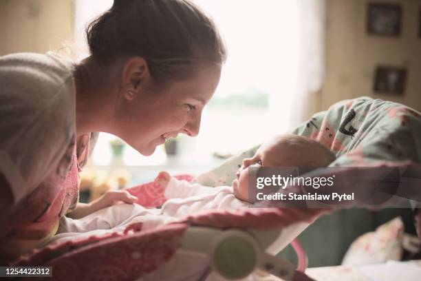 mother smiling face to face to her baby - prams stock pictures, royalty-free photos & images