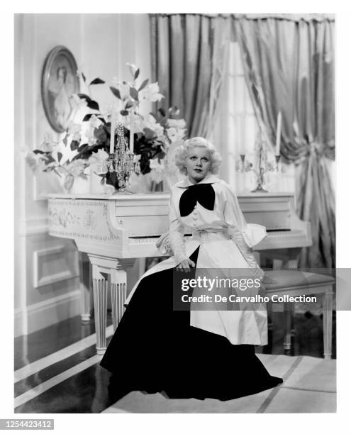 Actress Jean Harlow as 'Lola Burns' sitting by a white piano in a publicity shot from the movie 'Bombshell' United States.
