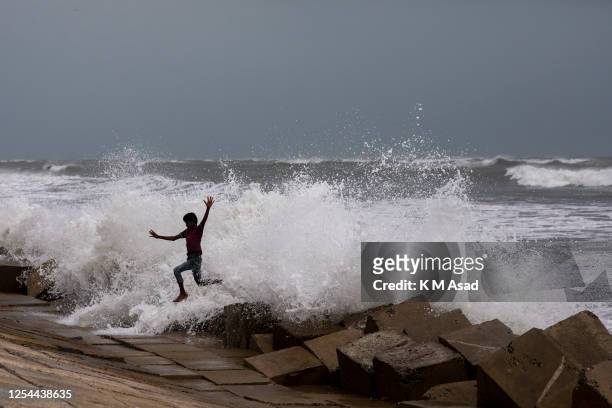 Boy tries to escape from a wave at Shahpori island beach in Teknaf ahead of Cyclone Mocha's landfall. Bangladesh has raised the cyclone warning...