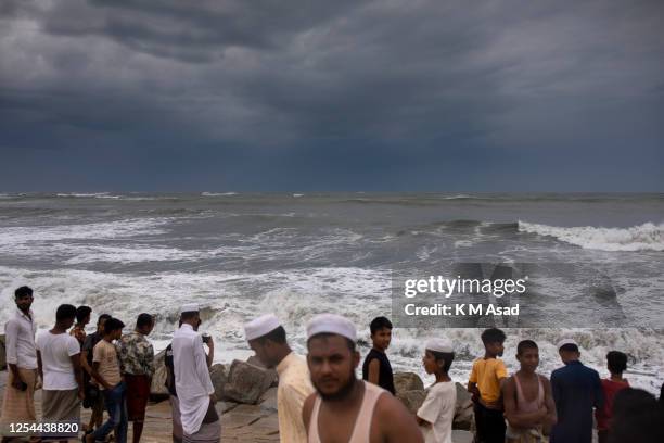 People gather at Shahpori island beach in Teknaf ahead of Cyclone Mocha's landfall. Bangladesh has raised the cyclone warning signal to 10 for Cox's...