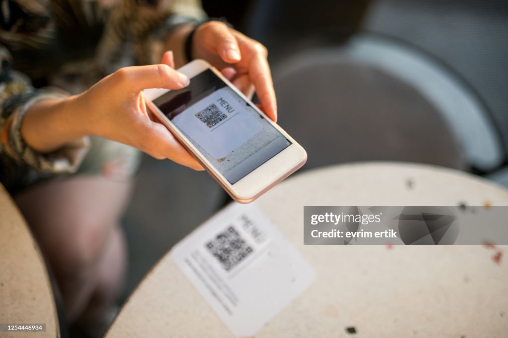 Woman scanning qr code for online menu