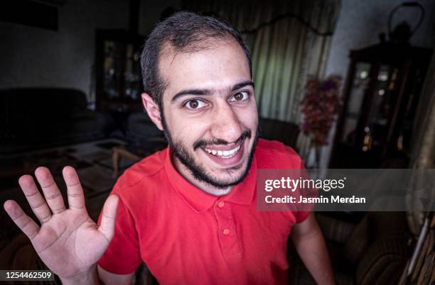 friendly happy man waving hand saying hello looking at camera - jordan or jordanian or the hashemite kingdom of jordan people or citizens ストックフォトと画像
