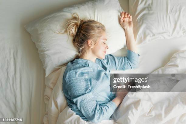 schöne blonde frau schlafen im bett - above view of man sleeping on bed stock-fotos und bilder