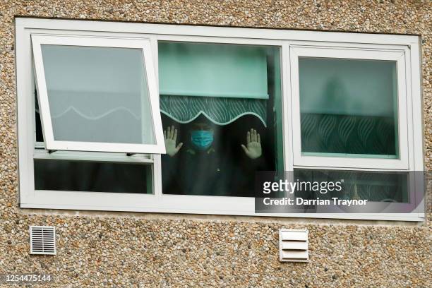 Man is seen looking out a window of the Flemington Towers Government Housing complex on July 06, 2020 in Melbourne, Australia. Nine public housing...