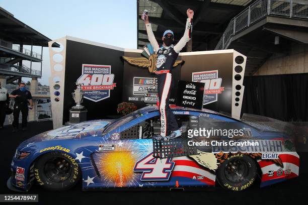 Kevin Harvick, driver of the Busch Light Patriotic Ford, celebrates in Victory Lane after winning the NASCAR Cup Series Big Machine Hand Sanitizer...