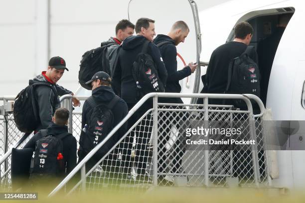 Zach Merrett, Orazio Fantasia, Darcy Parish of the Bombers are seen boarding a flight with Bombers head coach John Worsfold and Dyson Heppell of the...