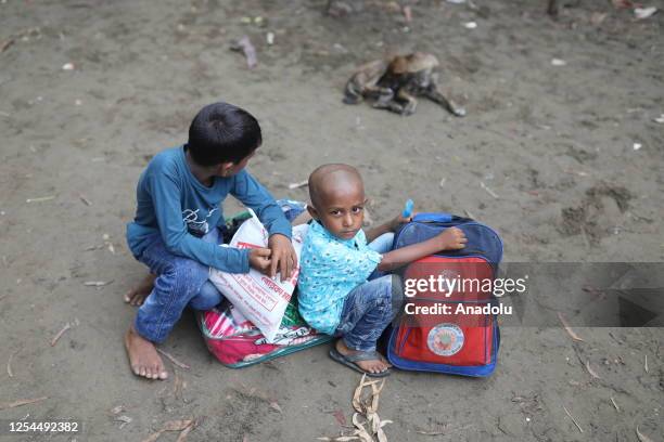 Bangladeshi coastal people leave their homes with their children to take shelter due to the expected impact of cyclone Mocha on May 13, 2023 in Cox's...