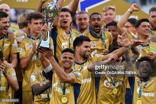 Zenit's Brazilian defender Douglas Santos holds the Russian national football championship trophy as he celebrates with teammates during an award...