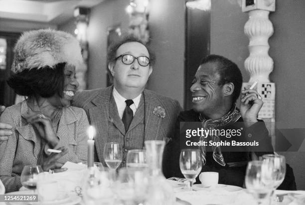 écrivain américain James Baldwin lors d'un déjeuner à Paris en compagnie de son agent littéraire et d'une amie.