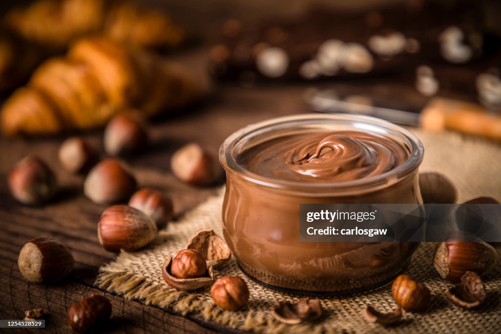 Tarro de cristal lleno de avellana y chocolate esparcido