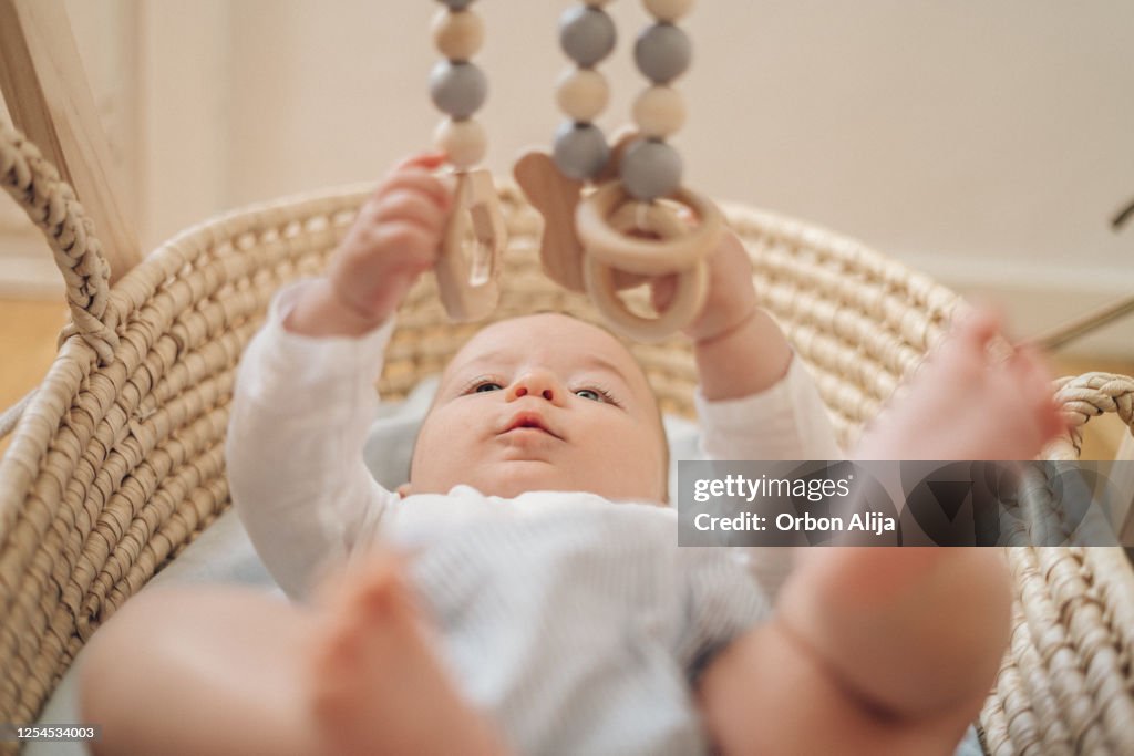 Bebé jugando con móvil hecho de madera