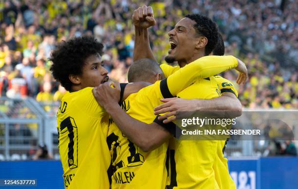 Dortmund's Dutch forward Donyell Malen is congratulated by Dortmund's German forward Karim Adeyemi and Dortmund's French forward Sebastien Haller...