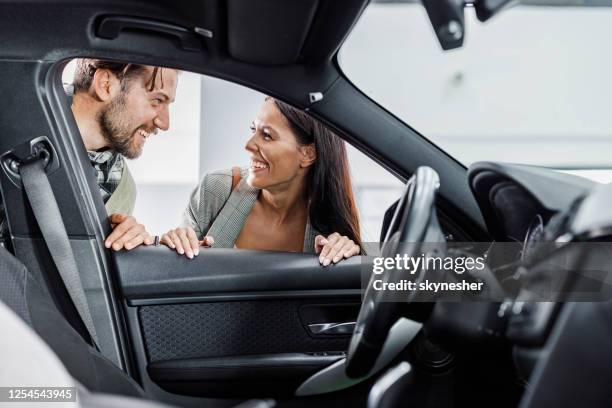 年輕的幸福夫婦在展廳買新車時交談。 - buying a car 個照片及圖片檔