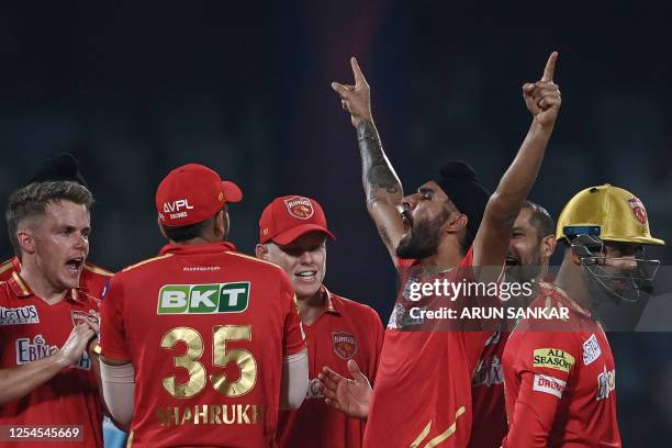 Punjab Kings' Harpreet Brar celebrates with teammates after taking the wicket of Delhi Capitals' David Warner during the Indian Premier League...