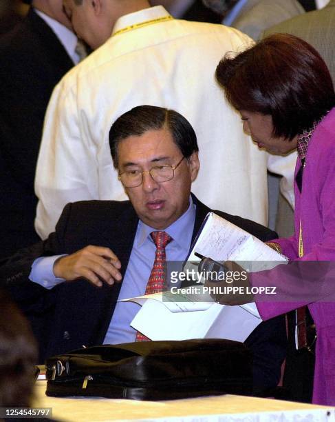 Philippine Foreign Minister Domingo Siazon looks over some papers with an unidentified aide at the foreign minister's meeting at the Asia-Pacific...