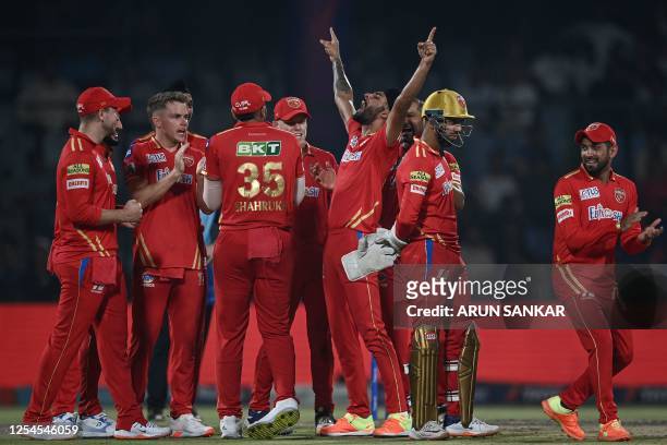 Punjab Kings' Harpreet Brar celebrates with teammates after taking the wicket of Delhi Capitals' David Warner during the Indian Premier League...
