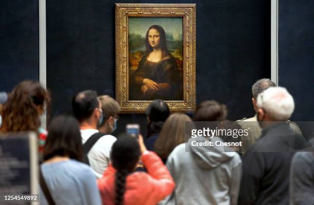 Visitors wearing protective face masks queue to see the painting of "Mona Lisa" also known as by Italian artist Leonardo Da Vinci at the Louvre...