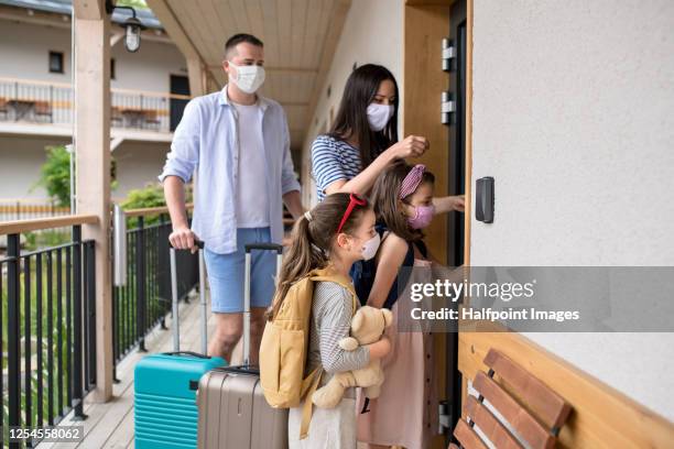 family with children and face masks outdoors by hotel in summer, holiday concept. - nueva-normalidad-concepto fotografías e imágenes de stock