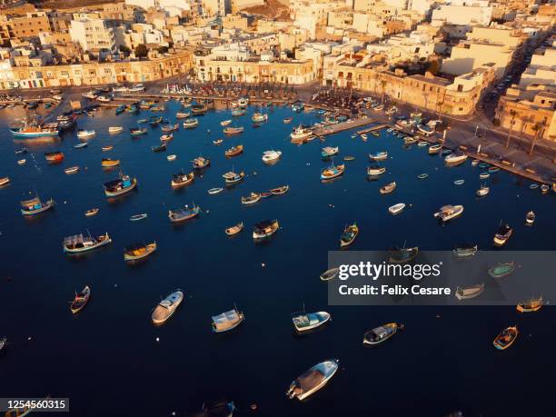 aerial view of the boats at marsaxlokk harbour in malta. a fishing village in the south of malta. - marsaxlokk stockfoto's en -beelden