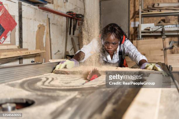 foto av en afroamerikansk kvinnlig snickare med cirkulär - snickeriarbete bildbanksfoton och bilder
