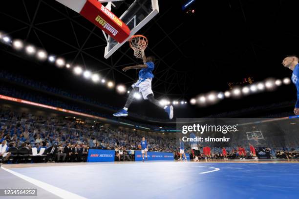 basketball player scoring slam dunk - stadium light stock pictures, royalty-free photos & images