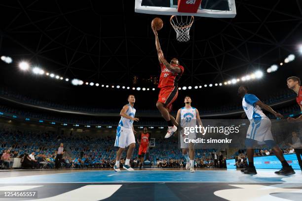 basketballspieler slam dunking ball - sportbegegnung stock-fotos und bilder