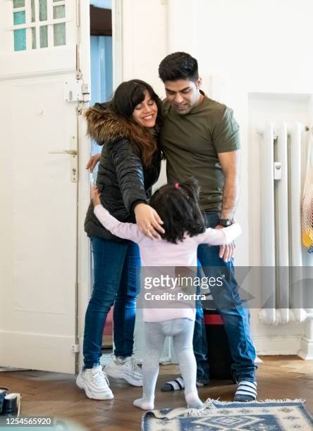 family hugging each other at house entrance - returning home after work stock pictures, royalty-free photos & images