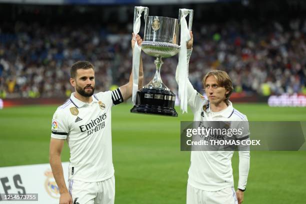 Real Madrid's Spanish defender Nacho Fernandez and Real Madrid's Croatian midfielder Luka Modric pose with their Spanish Copa del Rey trophy the Real...