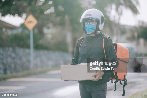 a package delivery senior man delivering the package carton to his client in the morning
