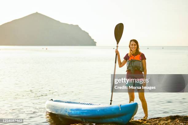 contented spanish female kayaker resting after paddling at dawn - oar stock pictures, royalty-free photos & images