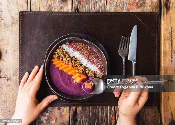 healthy raw food breakfast berry smoothie bowl with granola, goji berries, papaya, green buckwheat and coconut. - bocksdornfrucht stock-fotos und bilder