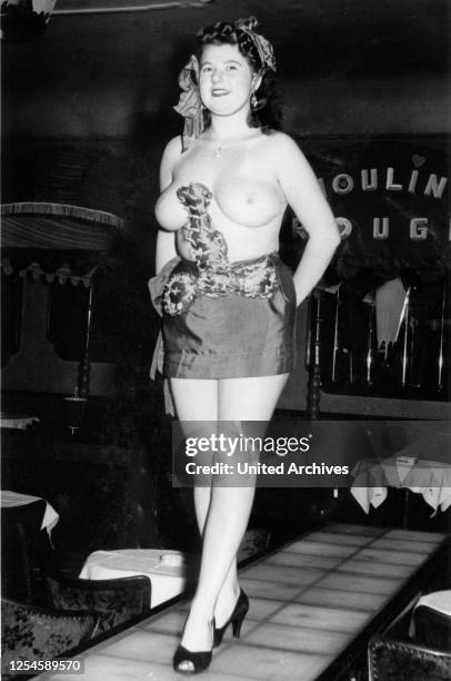 Eine junge Frau tritt in einer Show in einem Nachtclub auf der Reeperbahn in Hamburg oben ohne auf, 1950er Jahre.