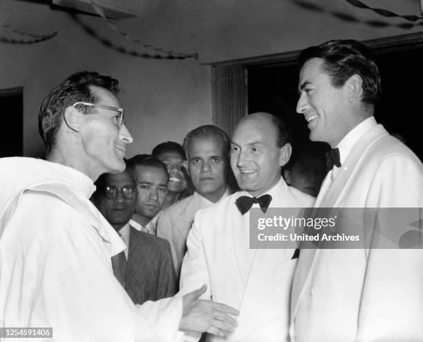 Der amerikanische Schauspieler Gregory Peck während der Dreharbeiten zu dem Spielfilm "The Purple Plain" 1954 bei Franzsikanerpater Paul, der auf...