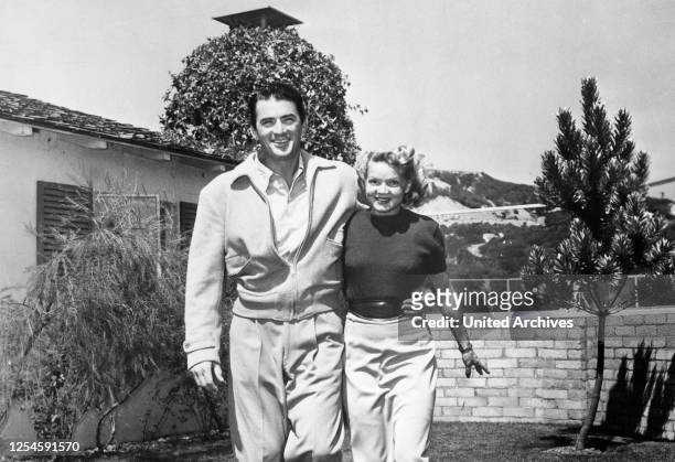 Der amerikanische Schauspieler Gregory Peck mit seiner Frau Greta im Garten, 1950er Jahre.