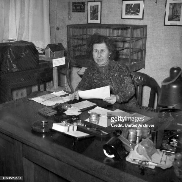 Eine Frau bei der Büroarbeit an ihrem Schreibtisch, Hamburg 1954.