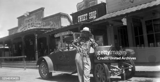 Ein Mann steht vor seinem Oldtimer auf der Straße einer Westernstadt, Las Vegas, Nevada, USA, 1954.