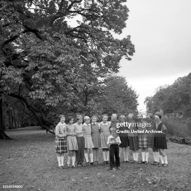 Kinder stellen sich zu einem Gruppenfoto in einem Park in Hamburg auf, 1954.