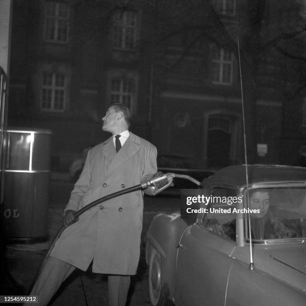 Der Jazzpianist und Komponist Fritz Schulz - Reichel mit seinem Mercedes Benz 190 SL Cabrio an der Zapfsäule einer Tankstelle, Hamburg 1955.