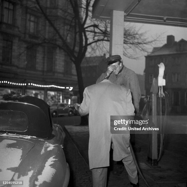 Der kopflose Jazzpianist und Komponist Fritz Schulz - Reichel mit seinem Mercedes Benz 190 SL Cabrio an der Zapfsäule einer Tankstelle, Hamburg 1955.