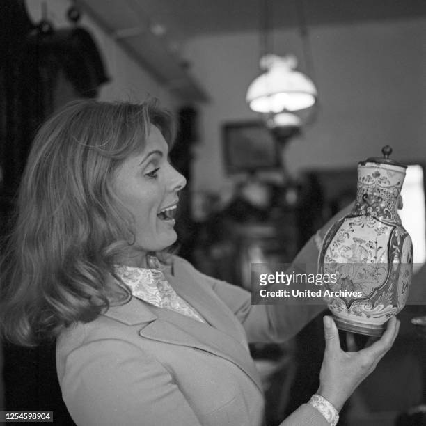 Die deutsche Schauspielerin Ruth Maria Kubitschek in einem Antiquitätenladen, Ende 1970er Jahre.