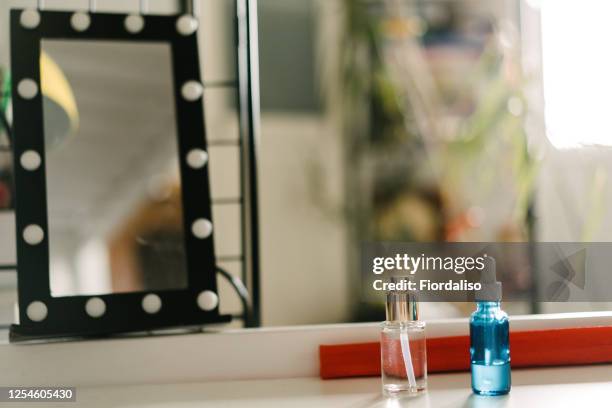 cosmetics standing on the table near the makeup mirror - make up table stock pictures, royalty-free photos & images