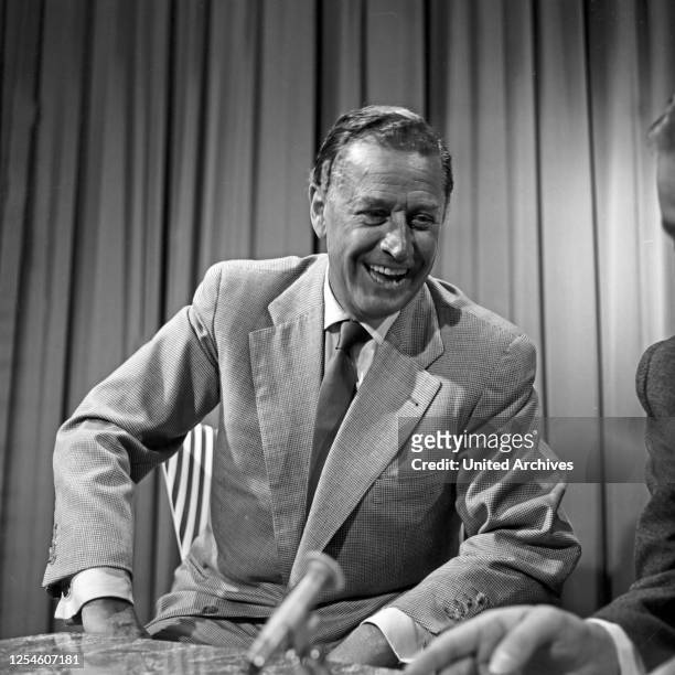 Der deutsche Schauspieler Hans Söhnker lachend in einem Interview, Deutschland 1950er Jahre.