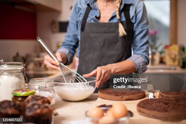 mulher assando em casa, preparação de bolo de gotejamento: preparando chantilly - female whipping - fotografias e filmes do acervo